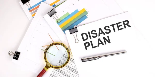 DISASTER PLAN text on white paper on light background with charts paper