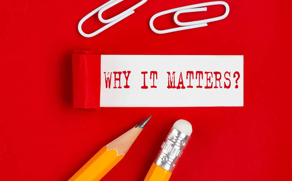 WHY IT MATTERS written on torn red paper with pencils and clips, business concept
