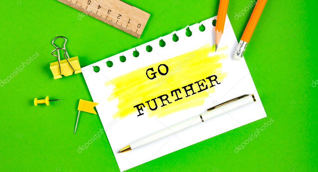 Text GO FURTHER sign showing on the green background with office tools