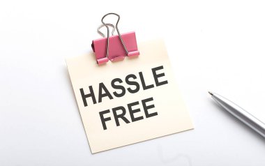 Etiketin üzerinde beyaz arkaplanda kalemle HASSLE özgür metni