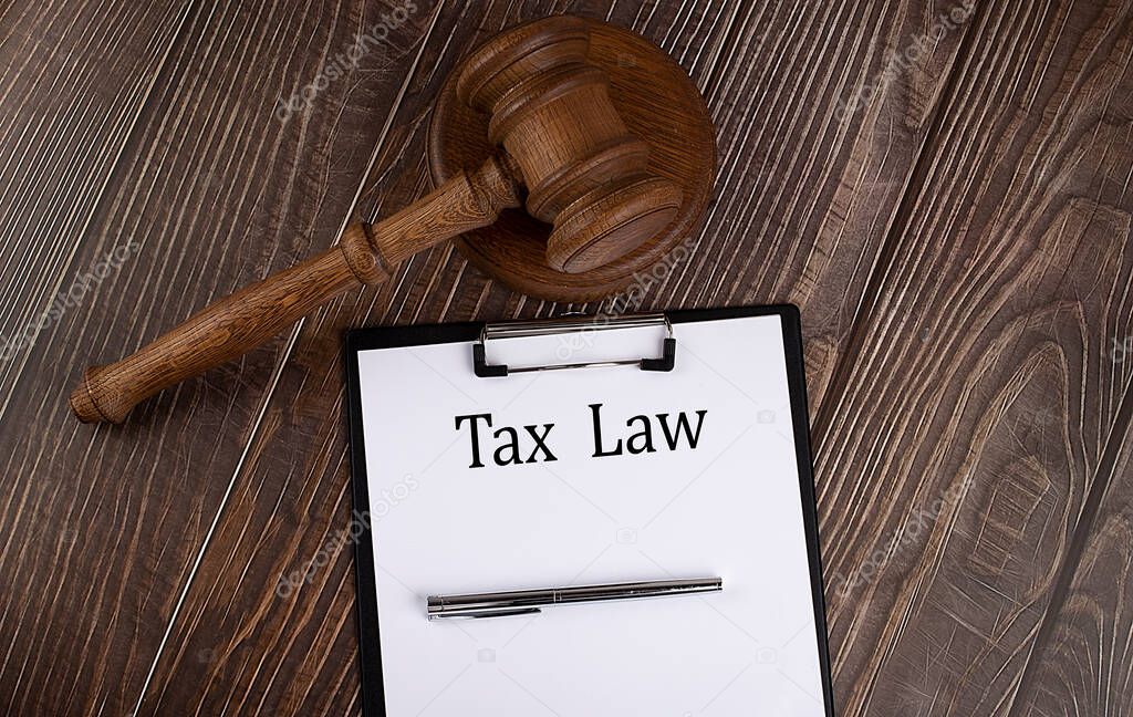 TAX LAW text on the paper with gavel on the wooden background