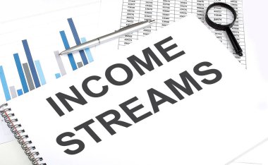 Not defterinde, Income STREAMS, büyüteç ve kalemin yanında, arkaplan grafiktir.