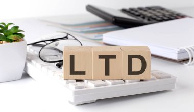 Klavyede ofis araçlarıyla birlikte tahta bir küpün üzerine LTD yazılmış.