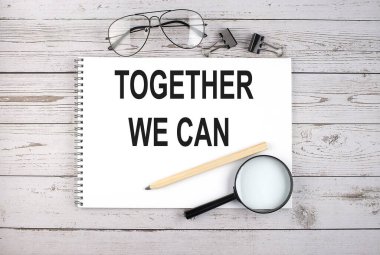 Kalem, büyüteç ve gözlüklerle ahşap masanın üzerine birlikte yazabileceğimiz bir defter.