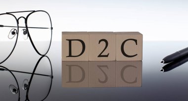 Close-up Of D2C Wooden Blocks on black background with glasses and pen