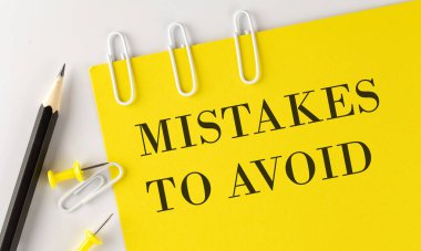 Beyaz arka planda ofis araçları olan sarı kağıttaki sözcüğe hata