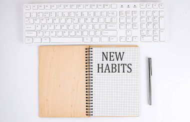 Not defterinde beyaz arkaplanda klavye olan NEW HABITS metni