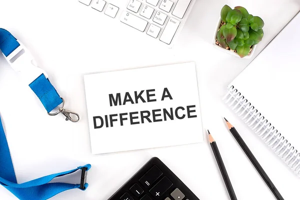 MAKE A DIFFERENCE Words on card with keyboard and office tools