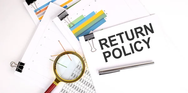 RETURN POLICY , text on white paper on light background with charts paper