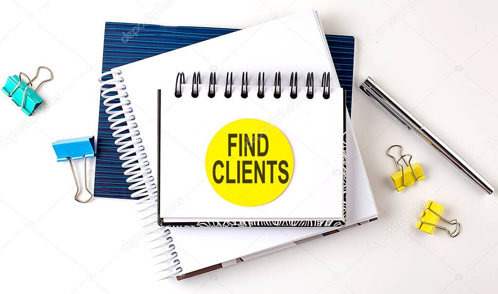 Sticker with FIND CLIENTS text on notebooks on white background