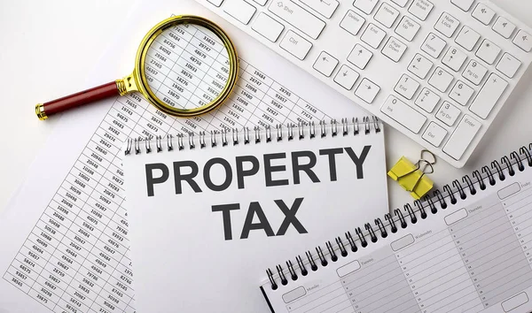 PROPERTY TAX text written on a notebook on the chart with keyboard and planning