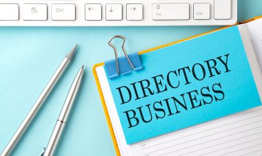 DIRECTORY BUSINESS text on sticker on blue background with pen and keyboard clipart