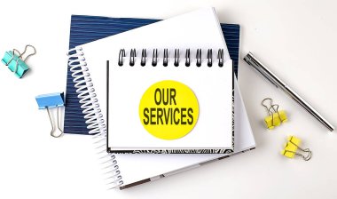 Beyaz arkaplandaki not defterlerine bizim SERVICES metnimizi yapıştıran etiket