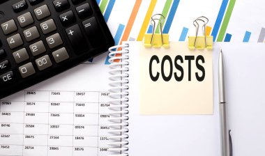 COSTS metin, hesap makinesi ile bir çıkartma üzerine yazılmış, grafik arkaplan üzerinde kalem.