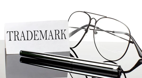 Text Trademark Papíře Světlém Pozadí Perem Brýlemi Obchod — Stock fotografie