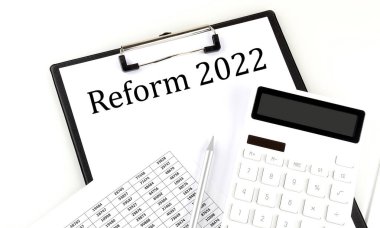 Dosyası ve hesap makinesi beyaz arkaplanda olan dizin üzerindeki REForm 2022 metni