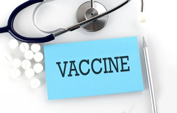 Texto Vaccine Mesa Com Estetoscópio Comprimidos Caneta Conceito Médico — Fotografia de Stock