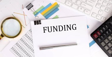 Işık arkaplanı üzerine beyaz kağıtta kağıt, klavye ve hesap makinesi ile eğlenceli metin