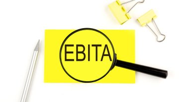 Etiketteki EBITA metni büyüteçle. Yukarıdan bak. İş dünyası