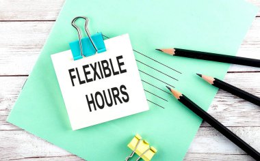 Tahta zemin üzerinde kalemler ile kısa notta FLEXIBLE SAATİ metin