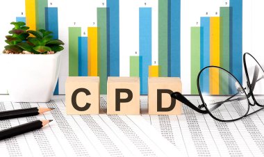 Tahta bloğa CDP kelimesi çizelge, gözlük ve kalemlerle yazılmış.