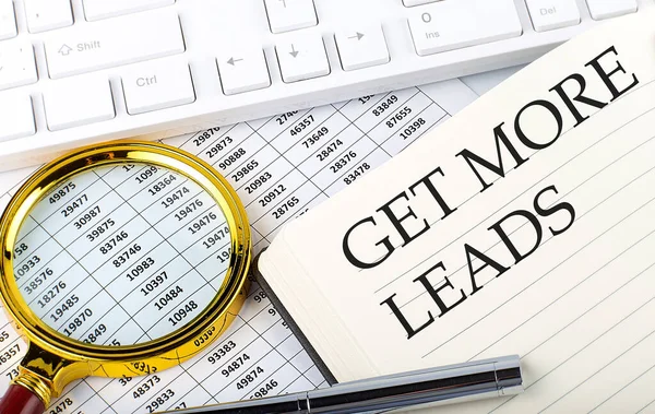 GET MORE LEADS text on the notebook with chart, magnifier,keyboard and pen