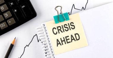 Kalemli çıkartmalar ve tahta zemin üzerinde CRISIS Ötesi yazılı defter