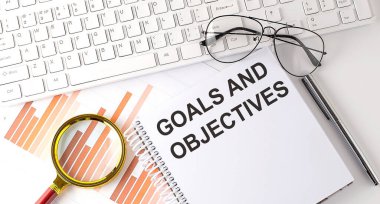 Hedefler ve OBJECTIVES Klavye, grafik ve gözlük ile defter üzerine yazılmış metin