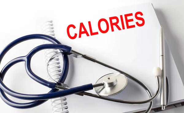 Text Kalorien Auf Weißem Hintergrund Mit Stethoskop Medizinisches Konzept — Stockfoto