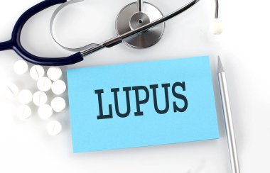 Masada steteskop, hap, kalem ve tıbbi konsept içeren LUPUS metni var..
