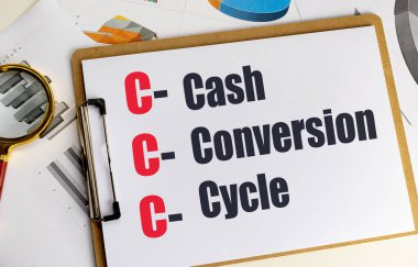 Para dönüşüm döngüsü kısaltması, finansal dökümanlar, çizelgeler ve büyüteçle birlikte panoda. . 