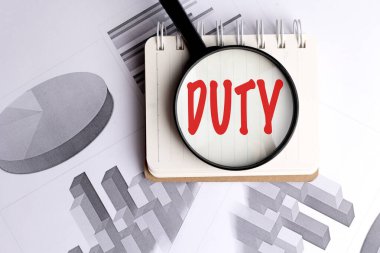 Kırmızılı görev sözcüğü, mali ve iş bağlamında çizelgeleri olan not defterine camla büyütülmüş. . 