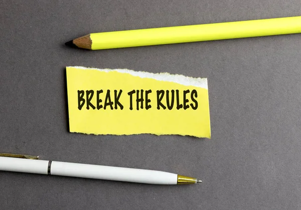 Gri arkaplandaki sarı yırtık biberin kurallarını boz . 