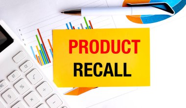 Ofis masasında beyaz kalem ve hesap makinesi olan sarı bir kağıtta ürün geri çağırma bildirimi. . 