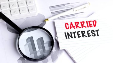 Ofiste büyüteç, kalem, hesap makinesi ve iş grafikleriyle dolu bir not kağıdına yazılmış ilginç bir mesaj. . 