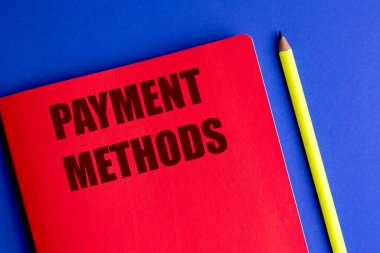 Ödeme metotları kırmızı defterde mavi arka planda sarı kalemle finansal konsepti temsil eder.. 