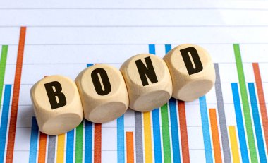 Renkli bar arkaplanı üzerinden ahşap yuvarlak bloklara yazılmış BOND sözcük, finans veya ilişkileri sembolize eder .
