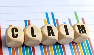 Renkli finansal bar tablosuna yerleştirilmiş ahşap yuvarlak bloklar hakkında CLAIM kelimesi . 