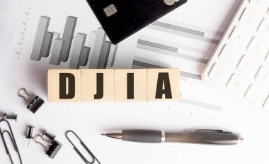 Ahşap bloklarda DJIA kısaltması. Finansal tablolar, kalem, hesap makinesi ve ofis malzemeleri.. 