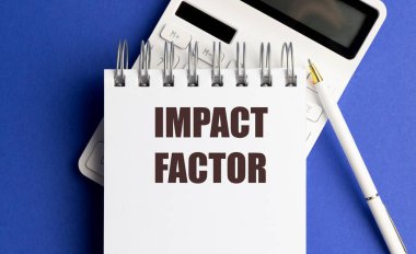 Hesap makinesi ve mavi arkaplanda kalem ile bir not defterine yazılan metin çarpma faktörü