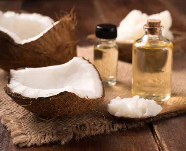 Kokosolie en cosmetische crème op houten achtergrond — Stockfoto