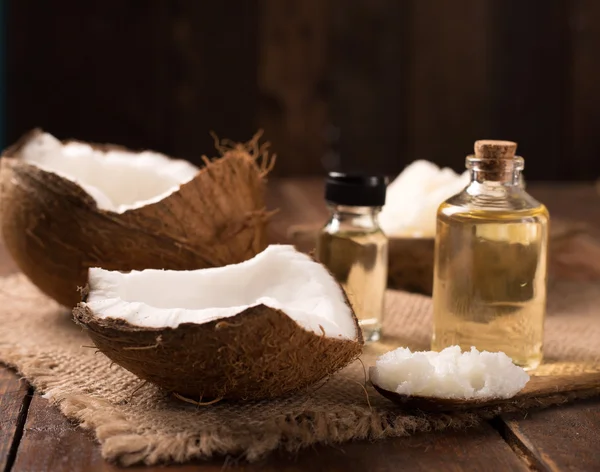 Kokosolie en cosmetische crème op houten achtergrond — Stockfoto