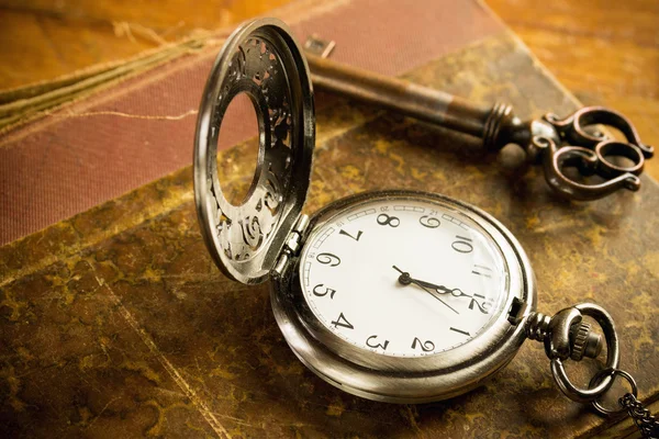 Pocket watch nyckel och gammal bok — Stockfoto