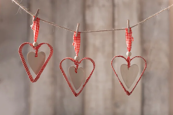 Handgemaakte harten opknoping over houten achtergrond — Stockfoto