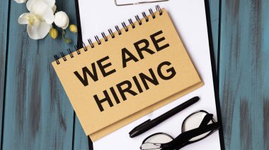 Yaratıcı üst görünüm düz yatıyordu. Not defterine kopyalama alanı olan metin alıyoruz. Parlak minimal stil. Çalar saatle. Yeni işe alım süreci kavramı, yeni takım üyelerinin taranması.