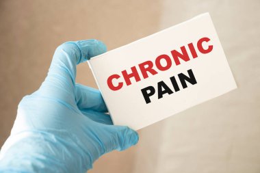 Doktorun elinde kronik ağrı teşhisi konan bir kart var. Seçici odaklanma. Tıbbi konsept.