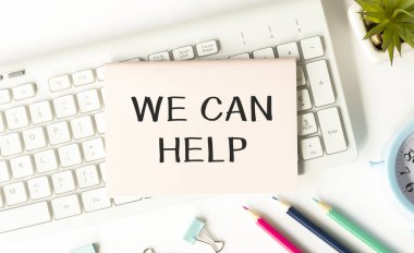 Kelime yazma metni. Sana yardım edebiliriz. Müşterilere ya da arkadaşlara iyi yardım sunan iş konsepti. Klasik ahşap masa üzerine yerleştirilen ekipman ve bilgisayar malzemeleri..
