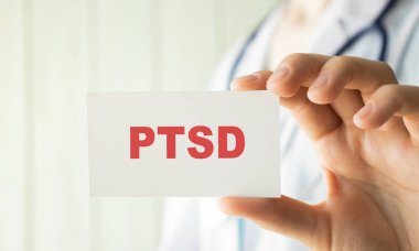 Doktor elinde TSSB tıbbi konsepti olan bir kart tutuyor.