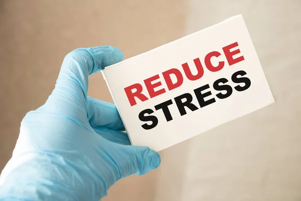 Reduce Stress Written on a Card in Hands of Medical Doctor. Healthcare relax stressfull job concept.