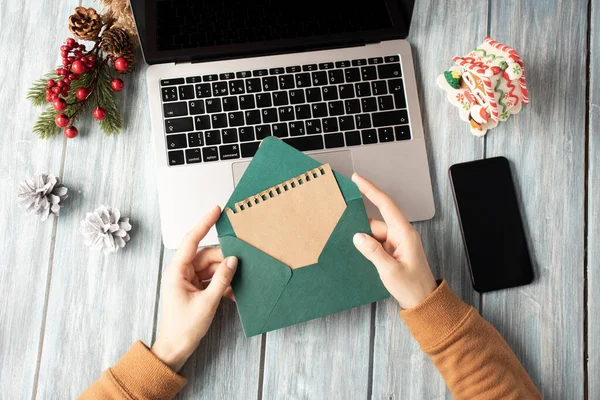 Mulher Segurando Envelope Verde Sobre Laptop Atmosfera Natal Escritório — Fotografia de Stock